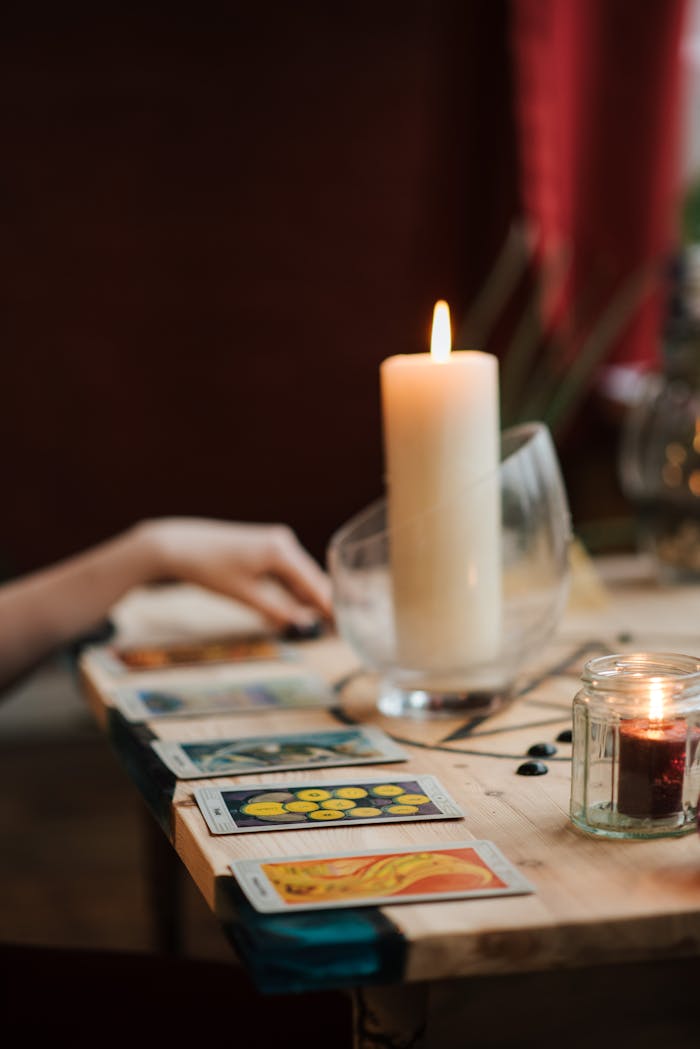 A mystical scene of tarot cards and candles on a wooden table, evoking a sense of enchantment.